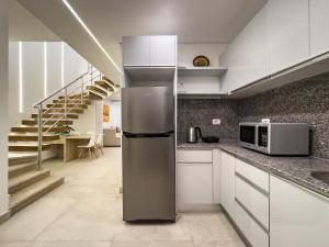 a kitchen with a stainless steel refrigerator and stairs at Poolside Townhome with 2 Masters, a Huge Terrace in El Gouna in Hurghada