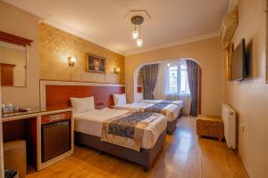 a hotel room with two beds and a television at Big Apple Hotel and Hostel in Istanbul +43 photos