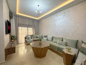 a living room with a couch and a table at charming and cozy studio with swimming pool in Marrakesh