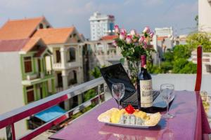 un tavolo con una bottiglia di vino e un piatto di cibo di Ninh Binh Family Hotel a Ninh Binh