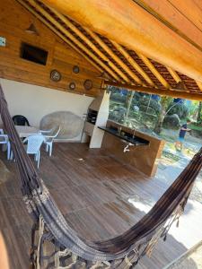 a hammock in a house with a kitchen and a table at Bela vista in Paraty
