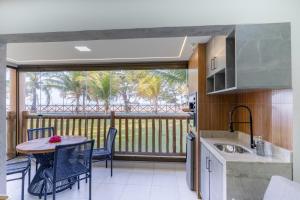 eine Küche und einen Balkon mit einem Tisch und Stühlen in der Unterkunft VG Sun Cumbuco - Apartamento de Temporada na Praia do Cumbuco in Cumbuco