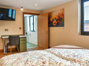 ein Schlafzimmer mit einem Bett, einem Schreibtisch und einem Gemälde in der Unterkunft Centilen Pedr - Daffodil - Ukc7078 in Mydroilin + 19 Fotos