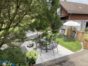 un patio avec une table, des chaises et un parasol dans l'établissement Im Toggi, à Wattwil