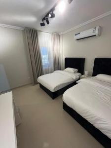 Habitación de hotel con 2 camas y aire acondicionado. en شقة متكاملة بجوار ملعب الجوهرة, en Yeda