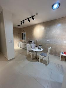 Una sala de estar con mesa y sillas y una cocina. en شقة متكاملة بجوار ملعب الجوهرة, en Yeda
