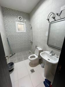 un baño con inodoro y lavabo en شقة متكاملة بجوار ملعب الجوهرة, en Yeda