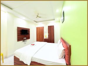une chambre avec un lit et une télévision au mur dans l'établissement Baliapand Road NewParwati Palace Inn- #Fully Air Condition with All Luxury Luxuary Rooms #Balcony Free Wifi # Parking & Lift Facilities- Best Luxuary Hotel In Puri, à Purî 23 autres photos