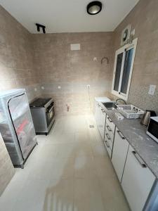 une cuisine avec un réfrigérateur et un plan de travail dans l'établissement شقة متكاملة بجوار ملعب الجوهرة, à Djeddah 13 autres photos