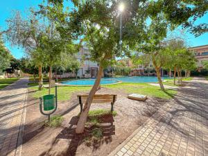 a park with a bench next to a tree at charming and cozy studio with swimming pool in Marrakesh