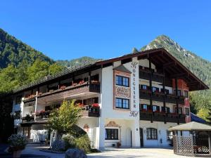 a large white building with balconies and a mountain at Ferienwohnung am Königssee in Schönau am Königssee