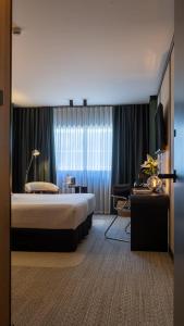 a hotel room with a large bed and a desk at Roc Blanc Hotel & Spa in Andorra la Vella
