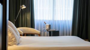 a hotel room with a bed and a chair and a window at Roc Blanc Hotel & Spa in Andorra la Vella +151 photos