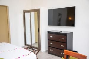 Un dormitorio con una cómoda y un espejo. en Hôtel du parc exotique, en Mbour