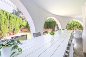 ein langer weißer Tisch in einem weißen Raum mit Bögen in der Unterkunft Villa Son Veri d'Alt in El Arenal