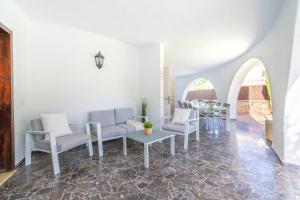 ein Wohnzimmer mit weißen Stühlen und einem Tisch in der Unterkunft Villa Son Veri d'Alt in El Arenal