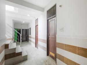 um corredor com escadas e portas num edifício em Hotel O Red Rose em Nova Deli
