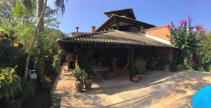 ein Haus mit einem Tisch und Stühlen davor in der Unterkunft Casa da Jataí - Piscina e Pomar - Barra do Sahy in São Sebastião