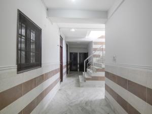 um corredor de um edifício com escadas e uma janela em Hotel O Red Rose em Nova Deli