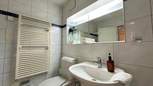 une salle de bain avec un lavabo, des toilettes et un miroir dans l'établissement Cave Suite, à Zurich