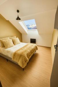 ein Schlafzimmer mit einem Bett mit Oberlicht in der Unterkunft Ma Montagne Chic 2 in La Bresse