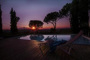 une chaise au bord d'une piscine avec un coucher de soleil dans l'établissement Agriturismo Fattoria Santo Stefano, à Greve in Chianti 76 autres photos