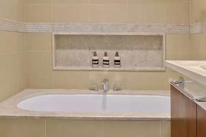 a bathroom with a tub with two bottles of wine at Luxurious 3 BR with Burj Khalifa View in Downtown in Dubai +30 photos