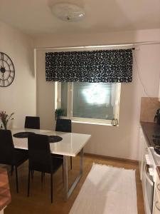 une cuisine avec une table et des chaises et une fenêtre dans l'établissement Apartment, à Rovaniemi