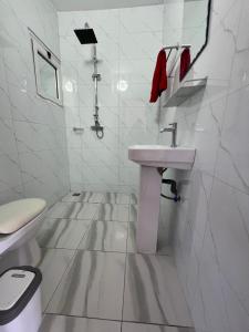 a white bathroom with a sink and a toilet at Jade in Assinie