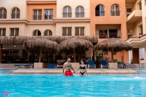 un homme et une femme debout dans une piscine dans l'établissement Rosa Boho Hotel And Aqua Park, à Hurghada