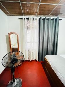 a bedroom with a fan and a bed and a mirror at Dhana Breeze in Weligama