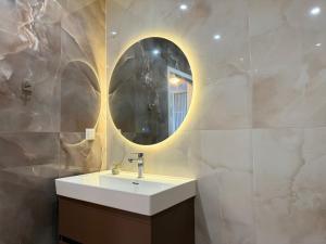 ein Badezimmer mit Waschbecken und Spiegel in der Unterkunft SkyWay by NightSpace- Modern City Apartment in Sofia + 13 Fotos