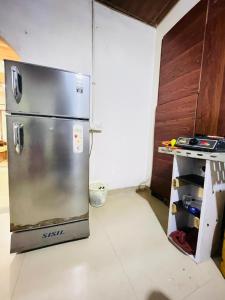 a kitchen with a stainless steel refrigerator in a room at Dhana Breeze in Weligama
