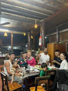 eine Gruppe von Menschen, die an einem Tisch in einem Restaurant sitzen in der Unterkunft An' Home Mai Chau in Mai Châu + 8 Fotos