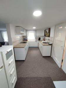 a large kitchen with white cabinets and a sink at Chata Luisa in Nová Komora +21 photos