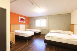 Cette chambre comprend 4 lits et une fenêtre. dans l'établissement Sporthotel in der Sport Arena Siggenthal, à Villigen