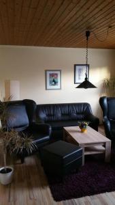 a living room with a leather couch and a table at Daisy 78 in Wilhelmshaven