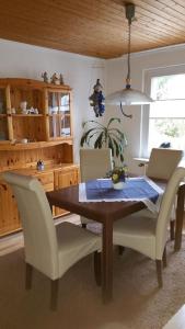 a dining room table with white chairs and a blue table cloth at Daisy 78 in Wilhelmshaven