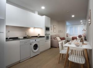 eine Küche und ein Wohnzimmer mit einem Tisch und einer Waschmaschine in der Unterkunft ITURRIONDO by Urdaibai Experience in Gernika
