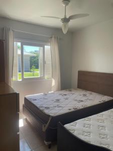 ein Schlafzimmer mit einem Bett und einem Fenster in der Unterkunft casa no centro proximo ao mar in Xangri-lá