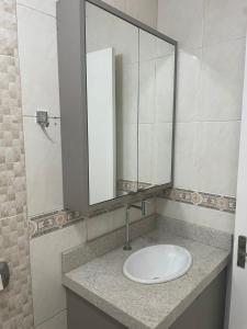 ein Badezimmer mit einem Waschbecken und einem großen Spiegel in der Unterkunft casa no centro proximo ao mar in Xangri-lá + 9 Fotos