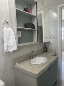 ein Badezimmer mit Waschbecken und Spiegel in der Unterkunft casa no centro proximo ao mar in Xangri-lá