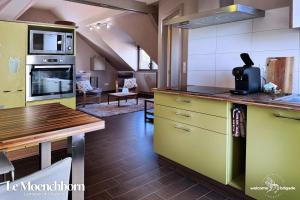 a kitchen with yellow and green cabinets and a living room at Combo Praelatenberg 2 appartements dans la même maison in Orschwiller