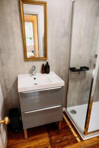a bathroom with a white sink and a shower at The Quaker Hall - Private Deck - Stunning Views in Falmouth