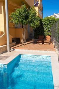 a blue swimming pool in front of a building at Pension Tina App 1 in Šilo