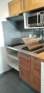 une cuisine avec des armoires en bois et un micro-ondes dans l'établissement Montagne, à Savines 4 autres photos