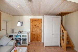 a living room with a wooden ceiling and a staircase at Ferienwohnung In Dänschendorf Auf Fehmarn in Fehmarn
