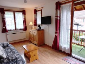 un salon avec un canapé et une télévision dans l'établissement Montagne, à Savines