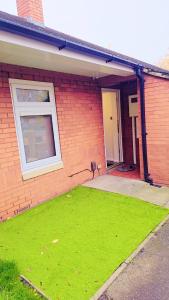 a brick house with a yard of green grass at Peaceful, Cosy and Central Stay in Nottingham in Nottingham