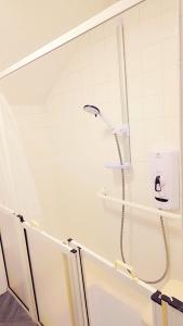 a shower with a shower head in a bathroom at Peaceful, Cosy and Central Stay in Nottingham in Nottingham